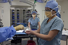 Nurses prepare an operating room for surgery.